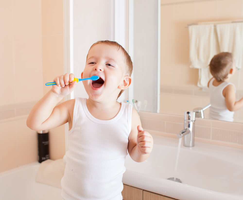 toddler learning how to brush his teeth